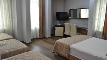 Habitación de hotel con dos camas, televisor, escritorio y espejo.