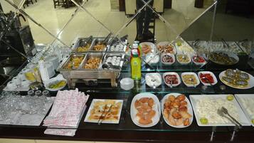 A buffet with various food items and utensils.