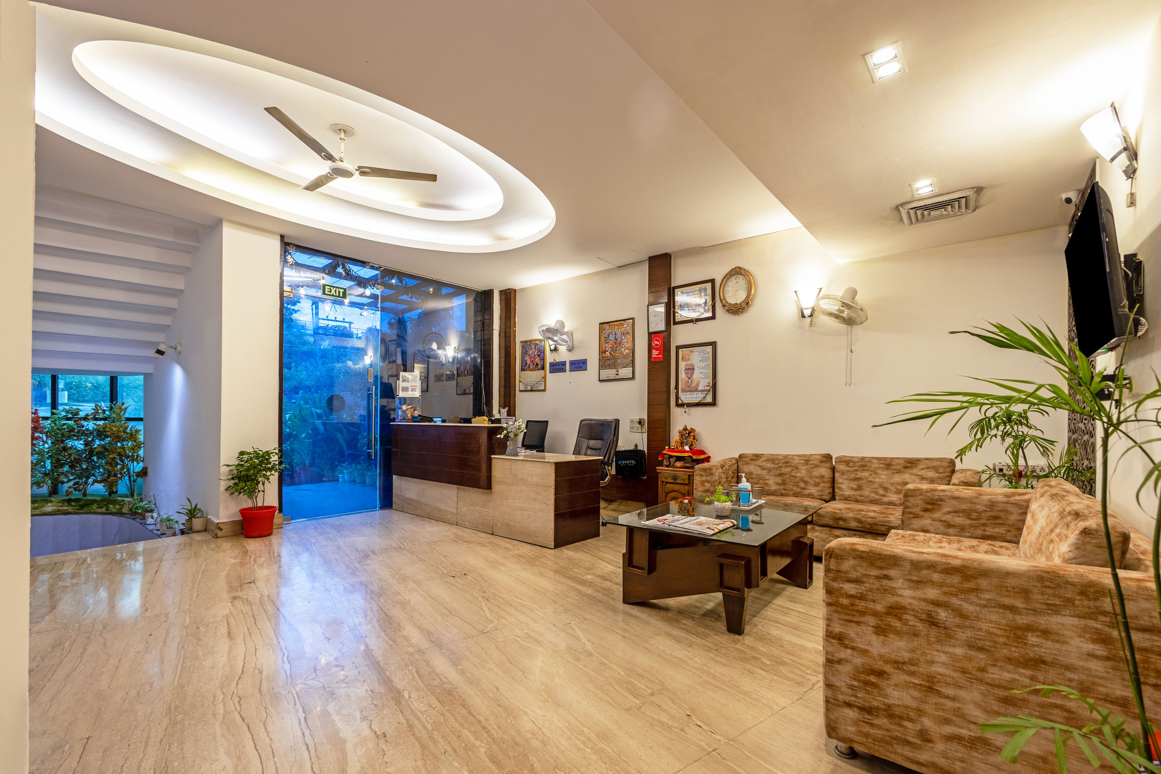 A modern living room with a reception desk, a ceiling fan, and a large window.