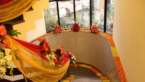 A curved staircase with floral decorations and drapes.