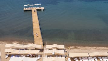 Een privéstrand, ligstoelen aan het strand, parasols, strandlakens
