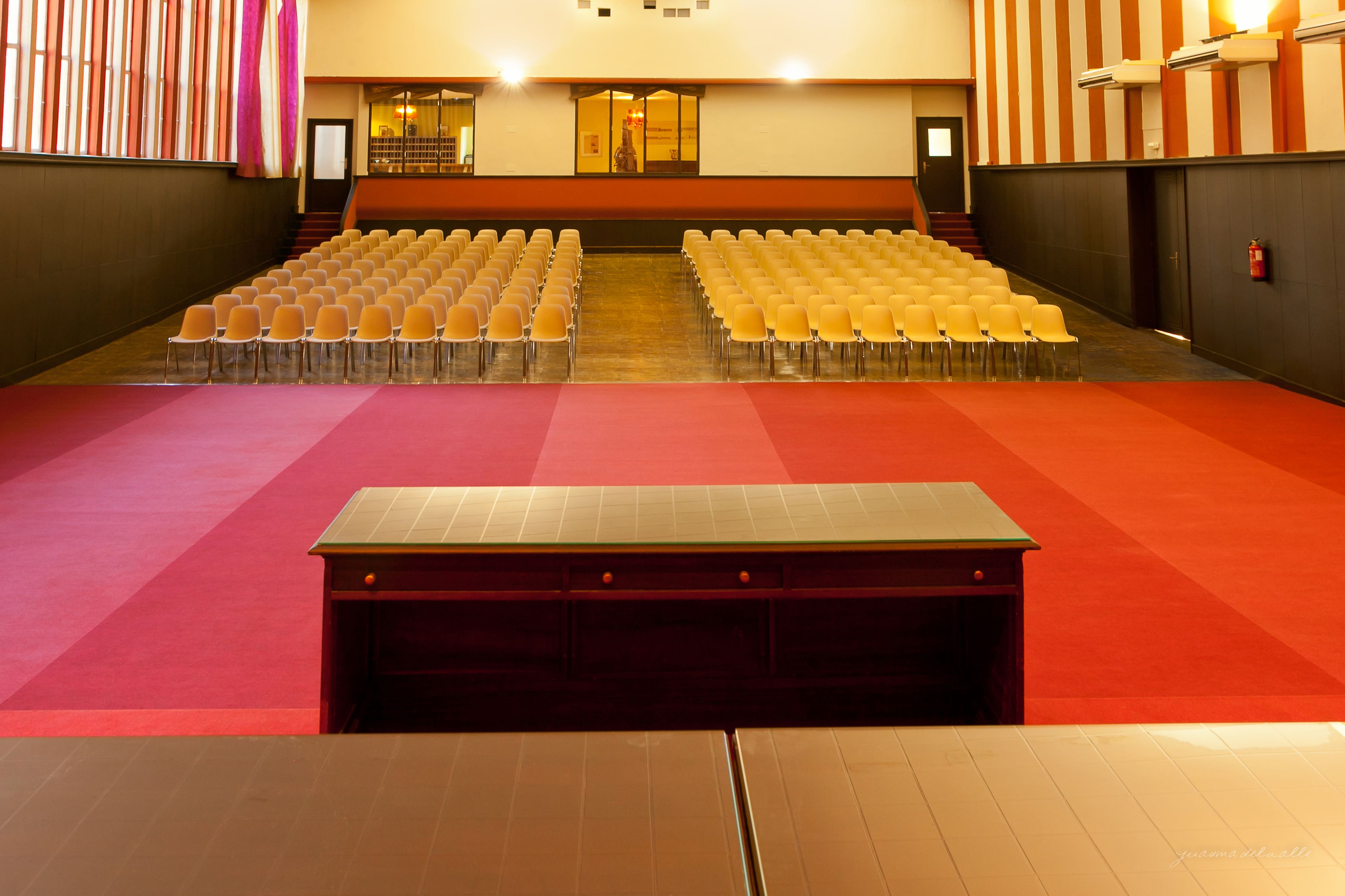 A large hall with rows of chairs and a stage area.