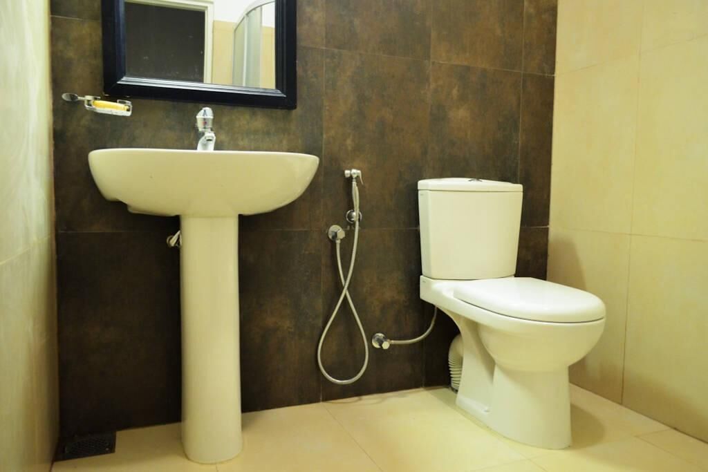 A bathroom with a white sink, a toilet, and a shower.