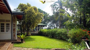 A well-maintained garden with a stone pathway leading to a gazebo. - Clovefield Villa (Hatton)