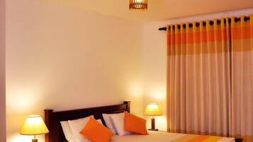A neatly made bed with a striped bedspread, two bedside lamps, and a wooden headboard.