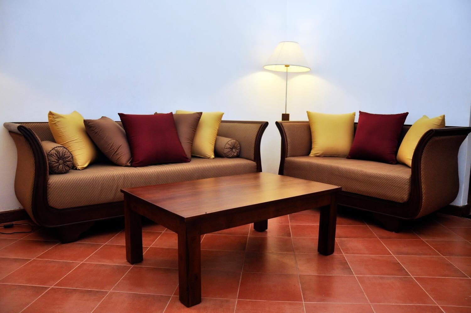 Una sala de estar con dos sofás, una mesa de centro y una lámpara de pie.