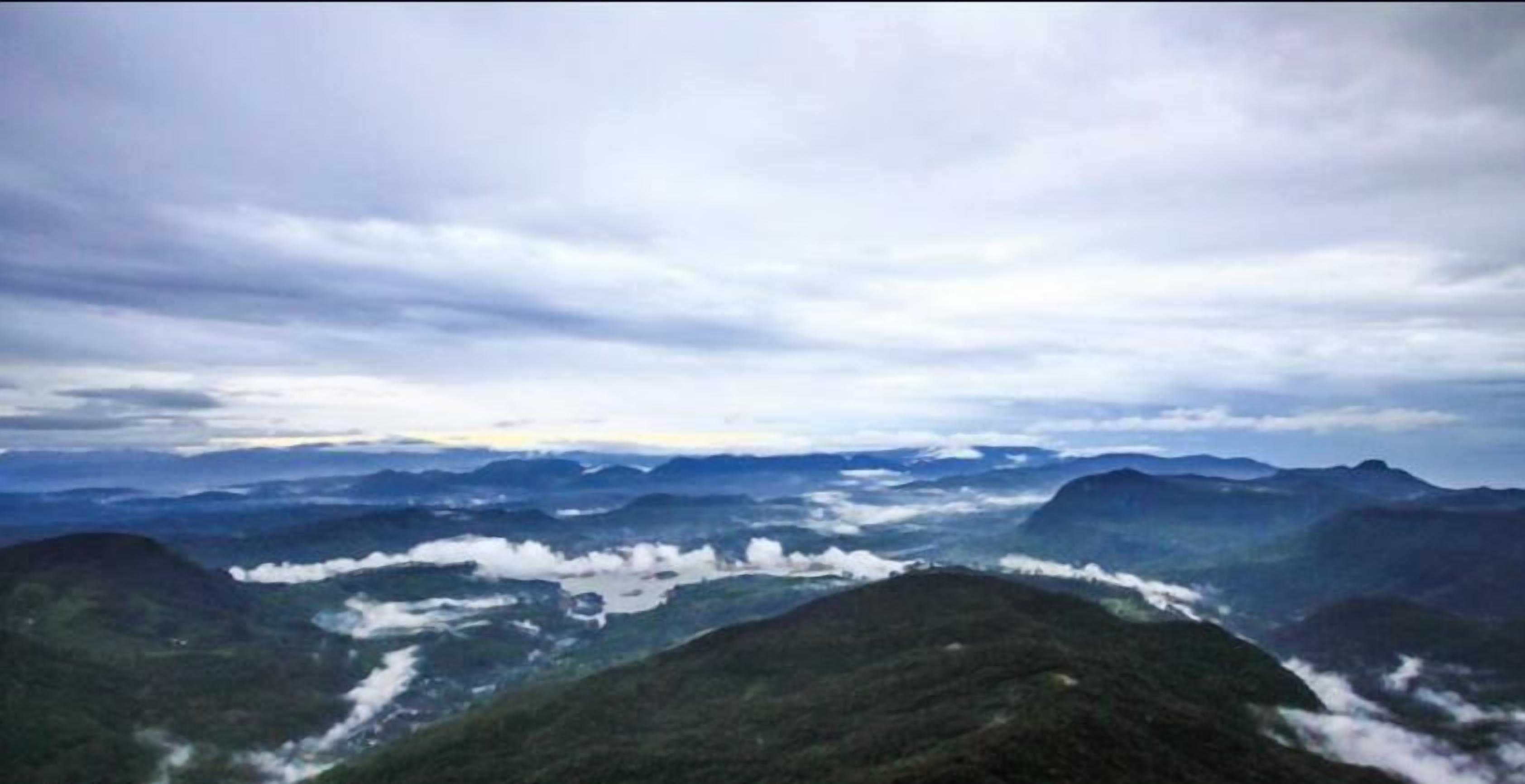Una vista panorámica de un paisaje montañoso con un valle abajo.