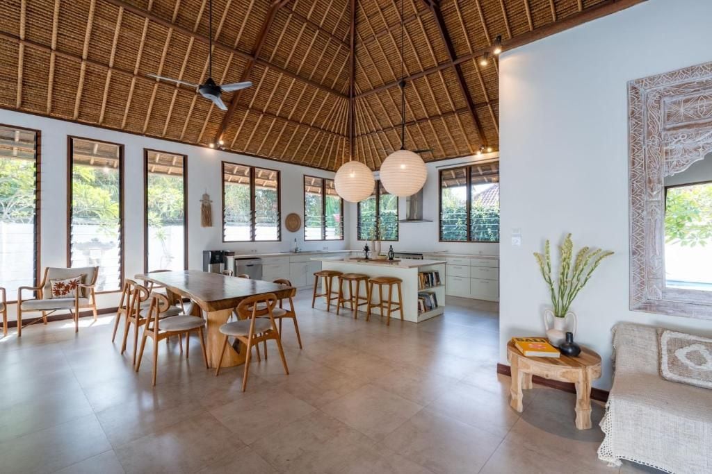 A spacious kitchen with a large island, wooden furniture, and a ceiling fan.