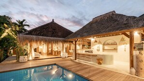 A poolside area with a thatched-roof structure, a bar, and a pool. - Castaway Resort (Lembongan Island)