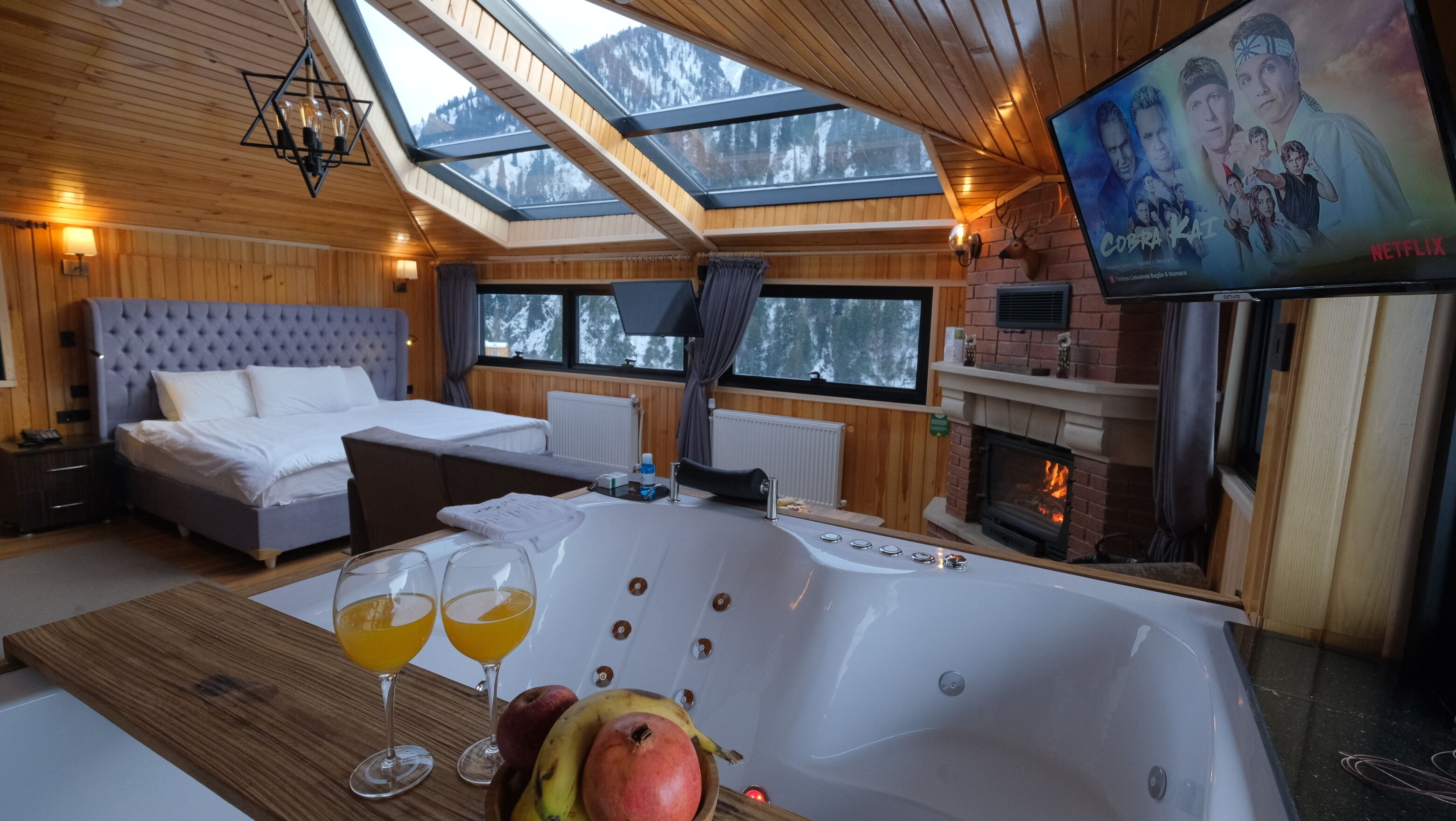 Una habitación acogedora con una cama grande, una bañera y una chimenea.