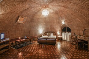 A room with a patterned floor, a bed, a desk, and a television. - Grand Norling Hotel's Resort (Gokarneshwar)