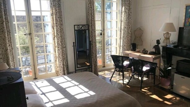 Un dormitorio con cama, escritorio y televisor.
