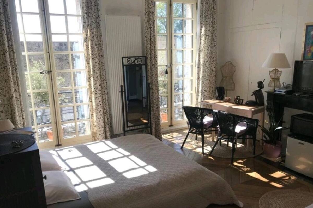 Un dormitorio con cama, escritorio y televisor.