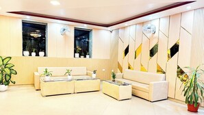 A modern lobby with a sofa set, a coffee table, and potted plants. - Suva Hotel (Birendranagar)