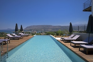 Piscine extérieure, parasols de plage, chaises longues