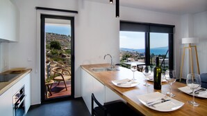 Een moderne keuken met een houten aanrecht, een spoelbak en een eethoek met een tafel gedekt voor twee personen.