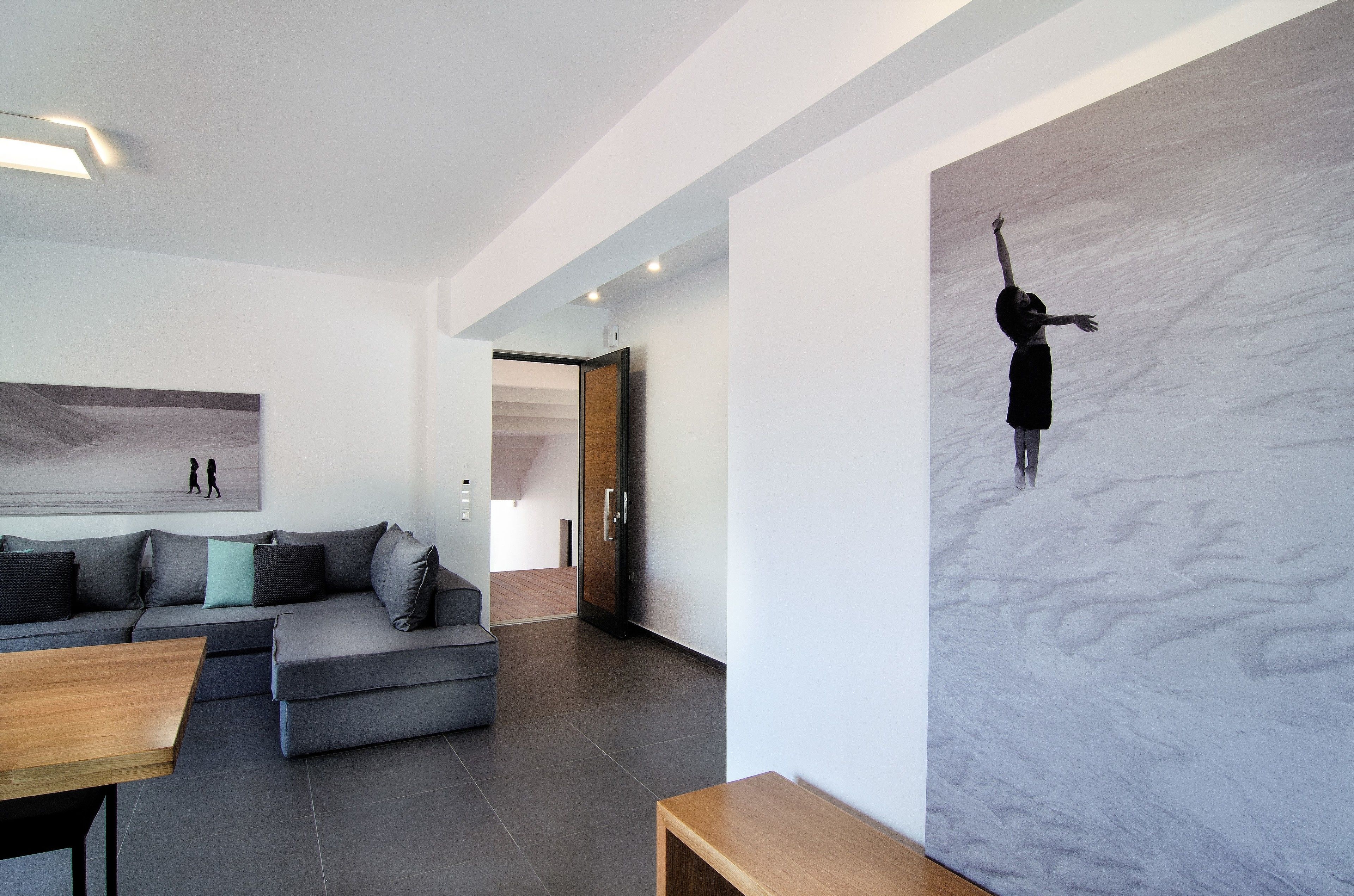 A modern living room with a sectional sofa, a wooden coffee table, and a large abstract painting on the wall.
