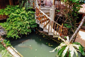 A wooden staircase leading to a wooden deck surrounded by lush greenery. - Klong Suan Plu Resort (Ayutthaya)