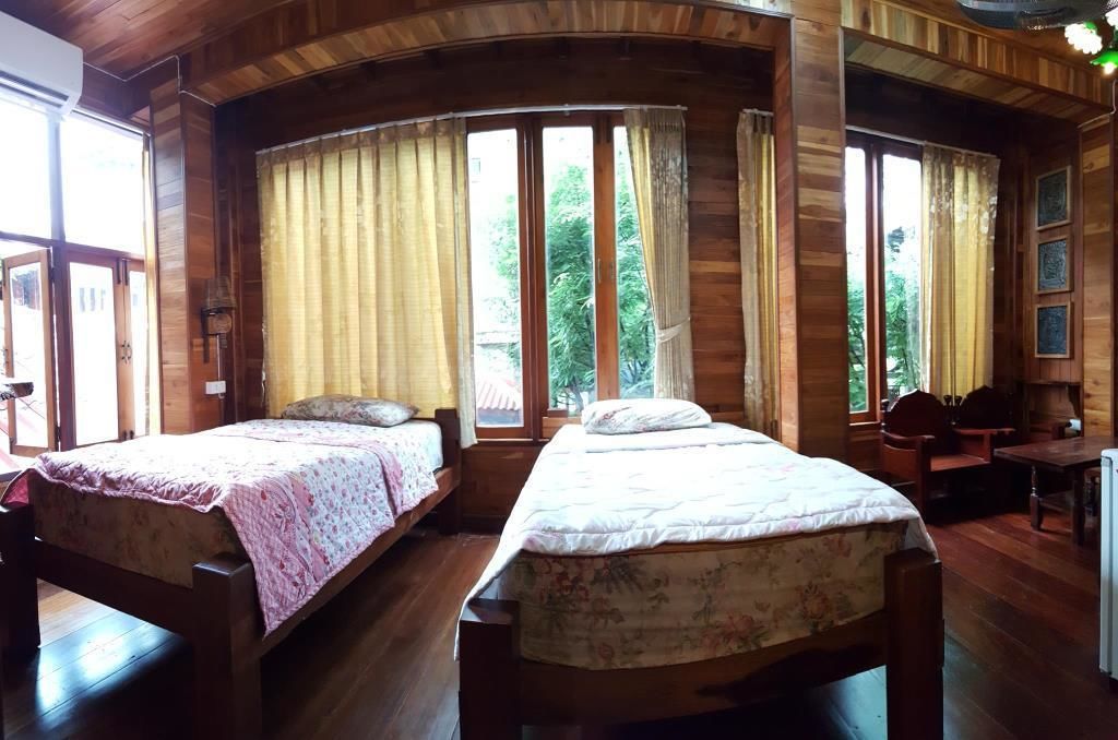 Eine Holzhütte mit zwei Betten, großen Fenstern und einem Essbereich.