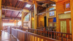 A wooden interior with a balcony, wooden railings, and a ceiling fan. - Klong Suan Plu Resort (Ayutthaya)