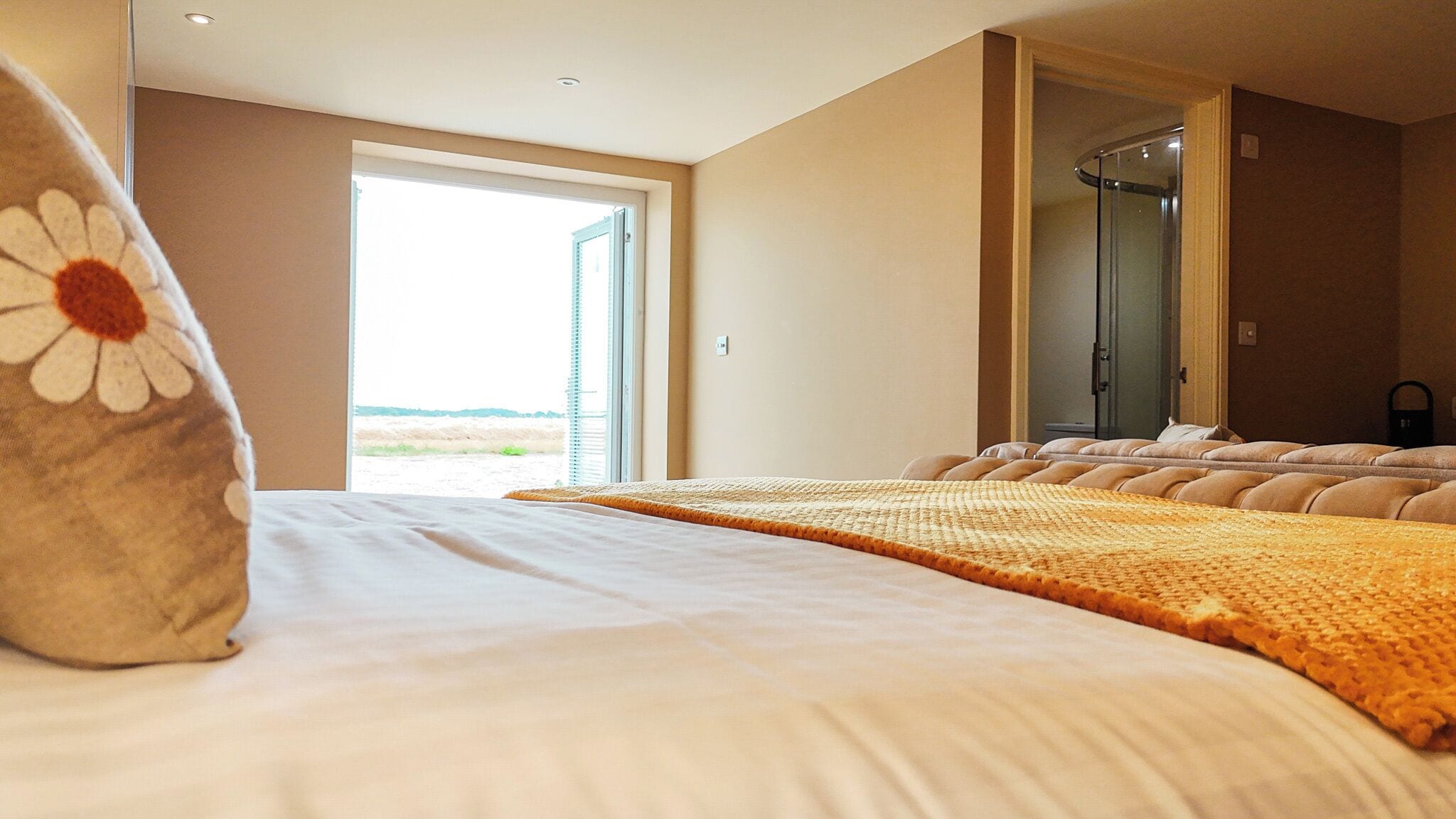 Une chambre à coucher avec un lit, une grande fenêtre et un espace douche.