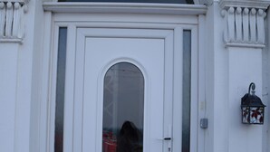 A white door with a glass panel and a sign above it that reads "KITTIWAKE HOUSE". - Kittiwake House (Port Erin)