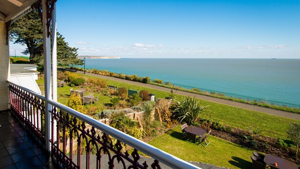 A balcony with a view of the sea, a garden, and a pathway. - The Clifton (Shanklin)