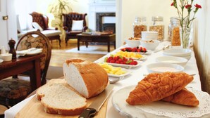 A breakfast buffet with bread, pastries, and fruit. - Willance House Guest House (Richmond)
