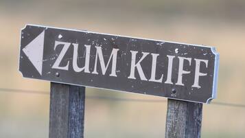 Una señal direccional con el texto "ZUM KLIF" y una flecha apuntando a la izquierda.
