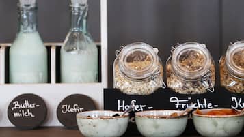 Una exhibición de alimentos que incluye frascos con ingredientes y tazones con cucharas.