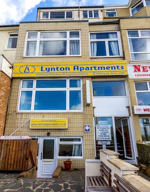 Un edificio de varios pisos con un cartel de Lynton Apartments publicitando alojamiento vacacional.
