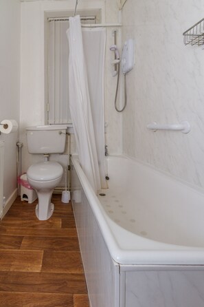 Un baño con inodoro, ducha y bañera.