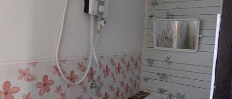 A bathroom with floral-patterned tiles, a white sink, and a mirror.