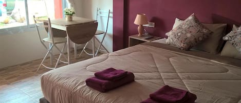 A hotel room with a bed, a desk, and a chair.