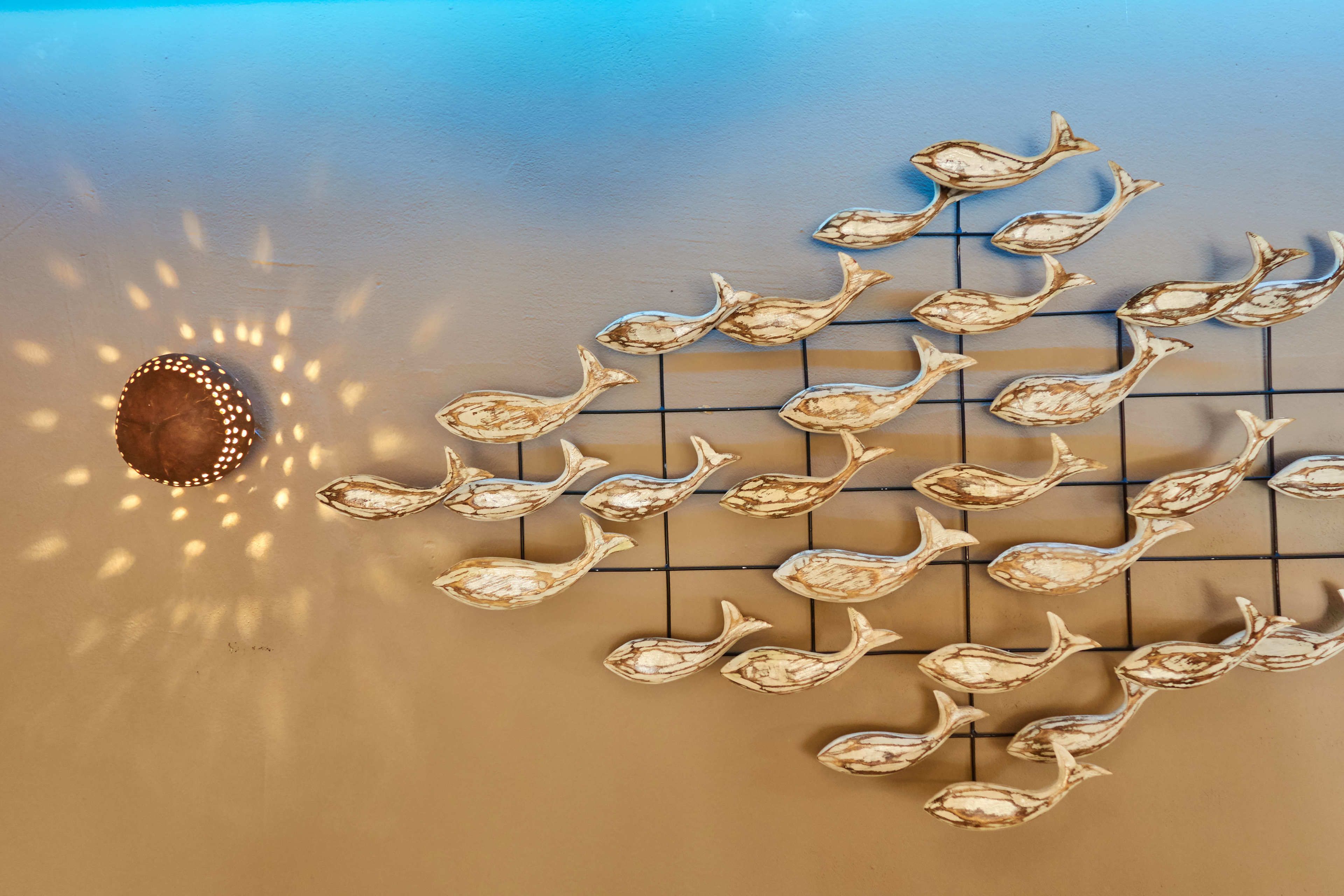 A wall with a grid pattern and decorative fish shapes.