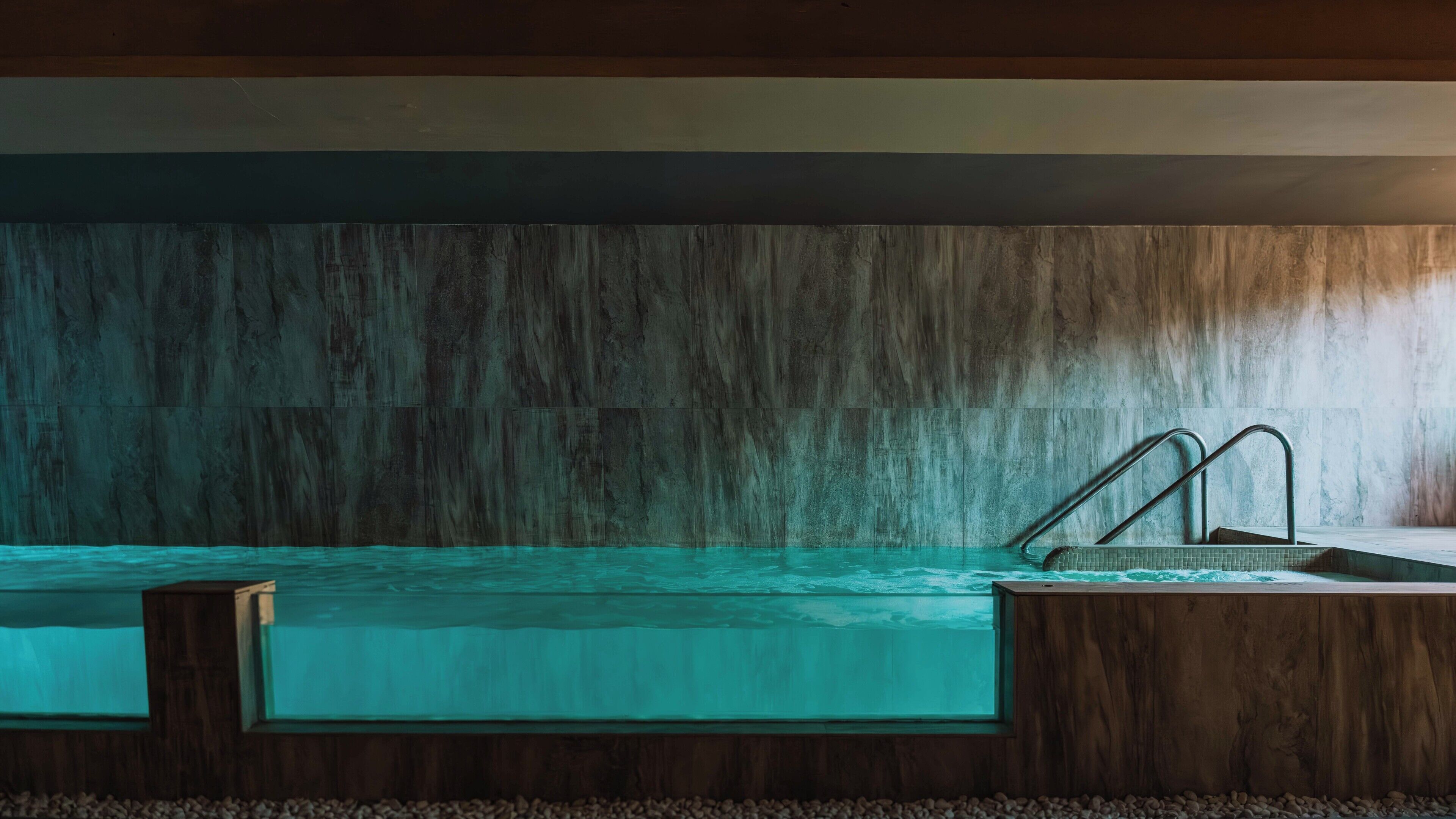 A swimming pool with a wooden deck and metal stairs.