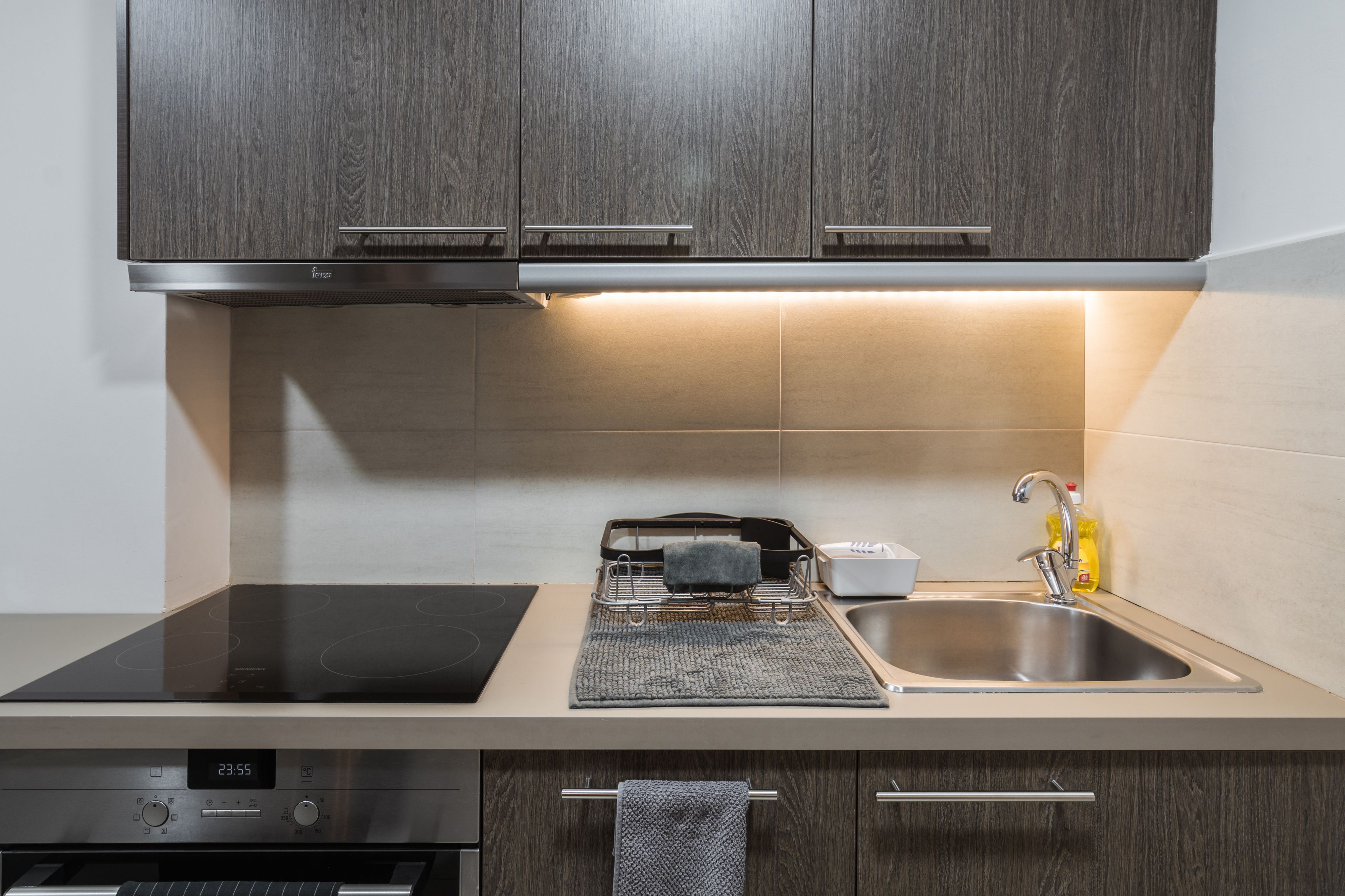 A modern kitchen with a built-in stove, a sink, and a dishwasher.