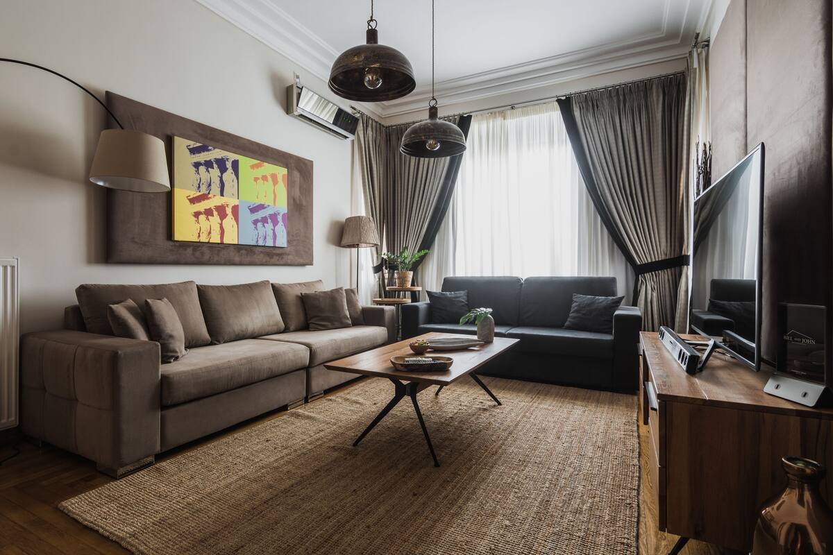 A modern living room with a sofa, coffee table, and a TV.