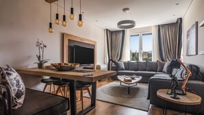 Una sala moderna con una mesa de comedor de madera, un sofá y un televisor.