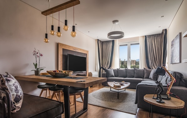 Acropolis Grand Residence | Living room | 50-inch Smart TV with cable channels, TV, Netflix