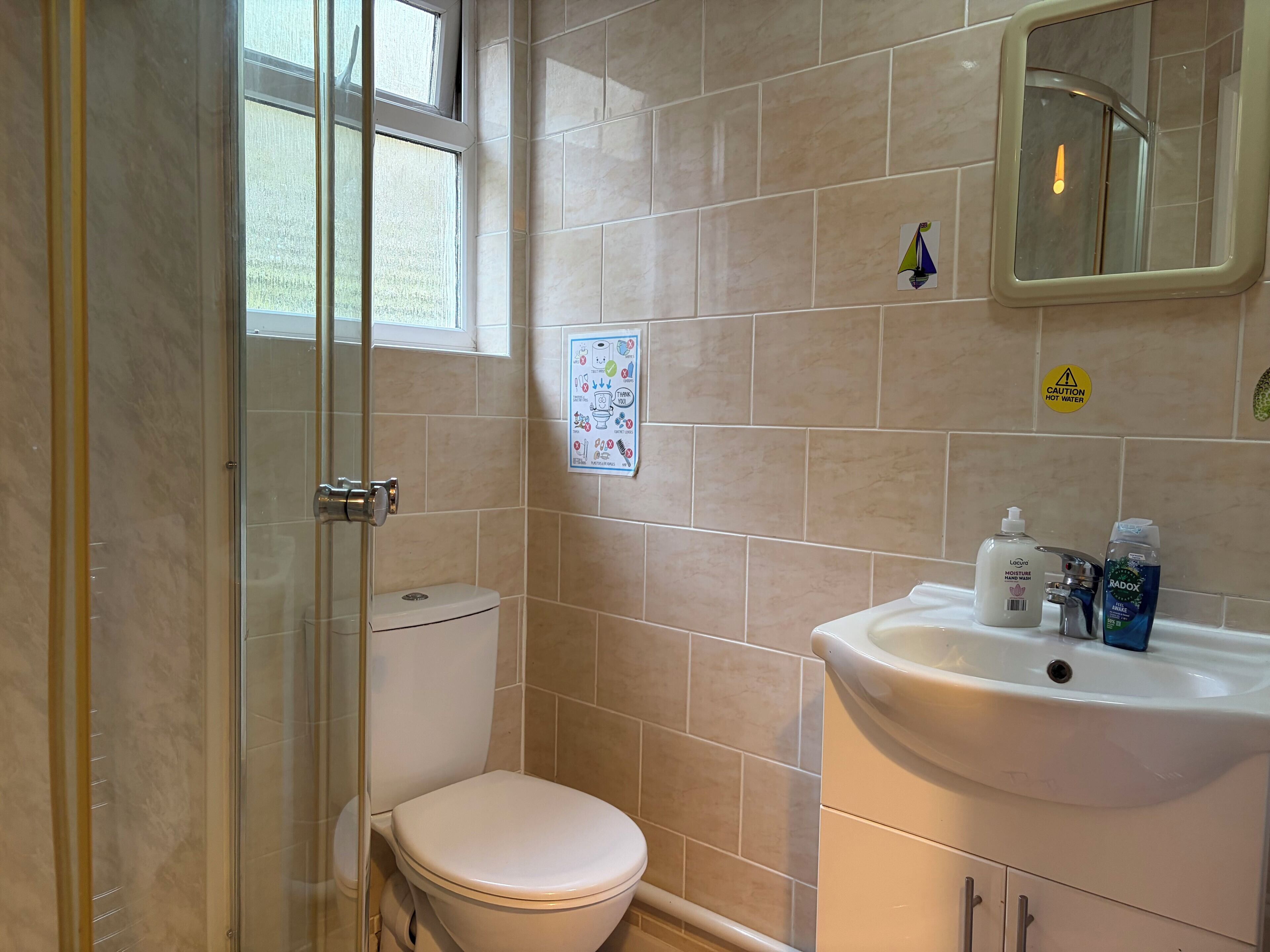 Un baño con inodoro, lavamanos y ducha.