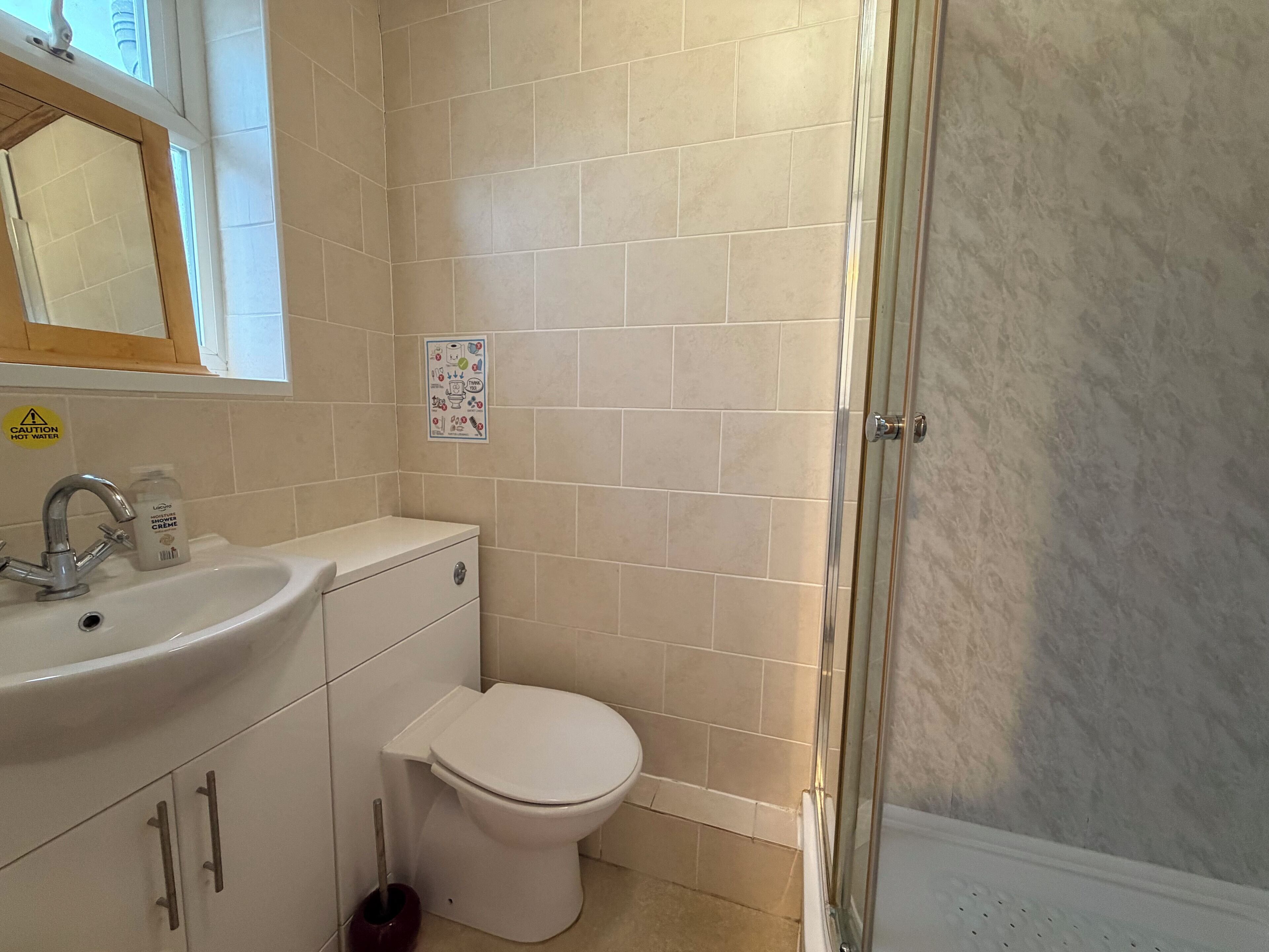 A bathroom with a sink, toilet, and shower.