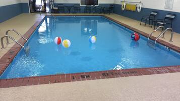 Una piscina techada, sillones reclinables de piscina