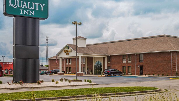 A Quality Inn hotel with a prominent sign, a parking lot, and a brick building facade.