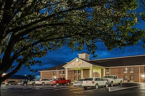 A Quality Inn with a brick exterior and a parking lot filled with cars.