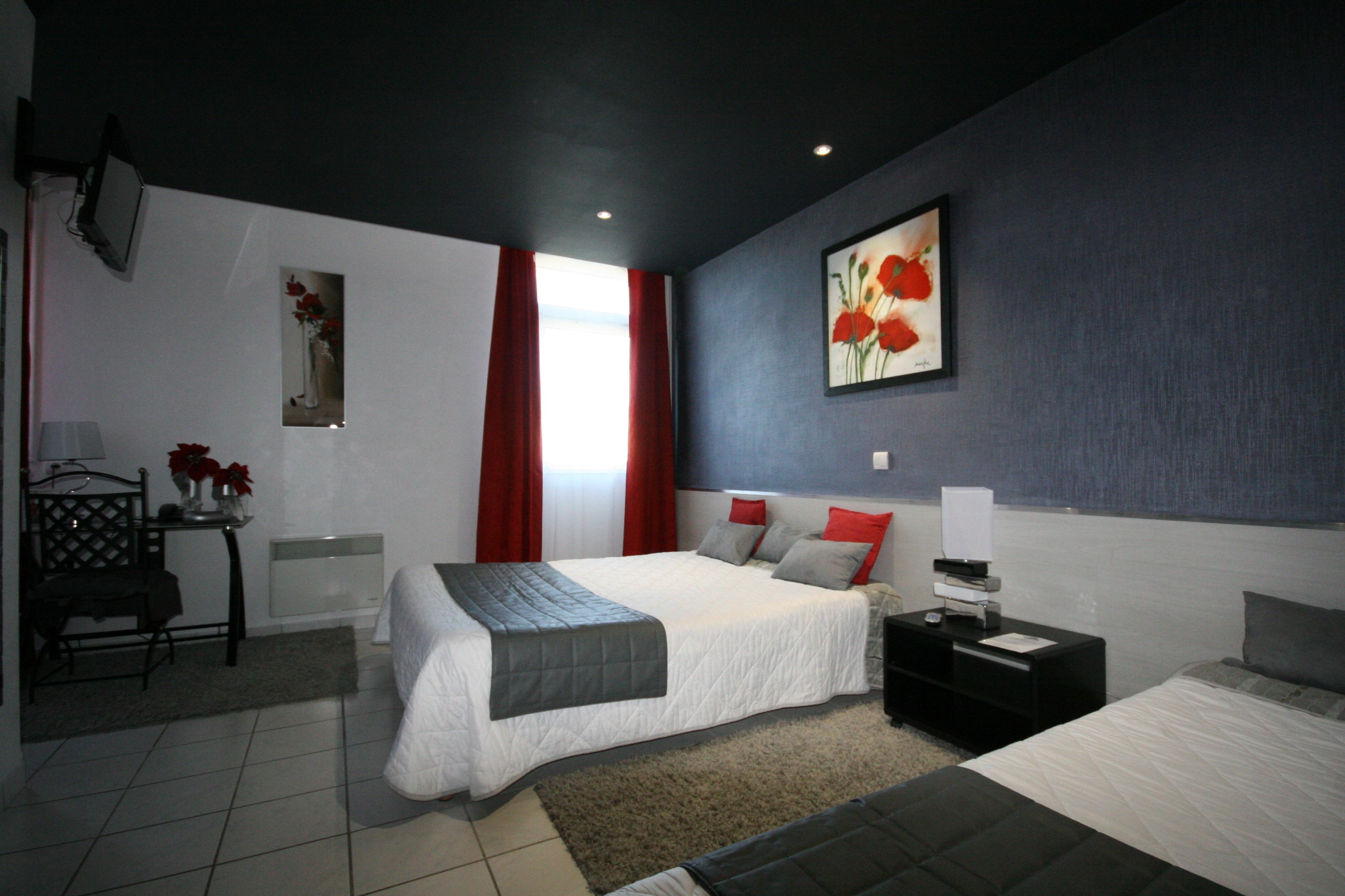 Een moderne slaapkamer met een groot bed, nachtkastjes, een bureau en een stoel.