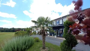 Un hôtel doté d’une pelouse bien entretenue, d’un palmier et offrant une vue dégagée sur le paysage environnant.