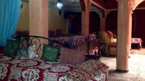 Una habitación tradicional con cama, una mesa y una lámpara colgante.