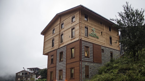 En bygning med flere etager, med en træfacade og detaljer i sten, og et skilt der viser "Hotel Bismark".