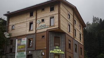 Un hôtel à plusieurs étages, de conception traditionnelle, qui se distingue par une enseigne bien visible portant le nom « AYDER SIMŞIROTEL ».